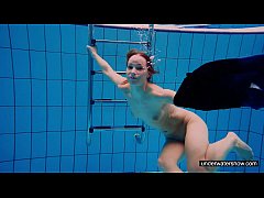 Молодая девушка голой плавает в бассейне 